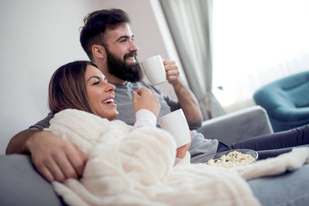 istock Cheerful romantic couple sitting on sofa and smiling 962066338