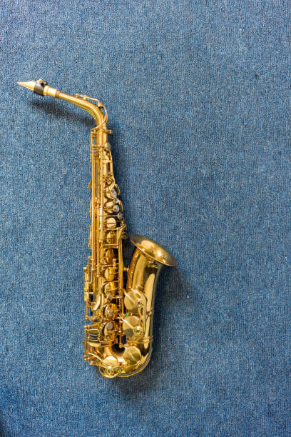 muzyk jazzowy złoty saksofon na niebieskim tle ściany - tenor zdjęcia i obrazy z banku zdjęć