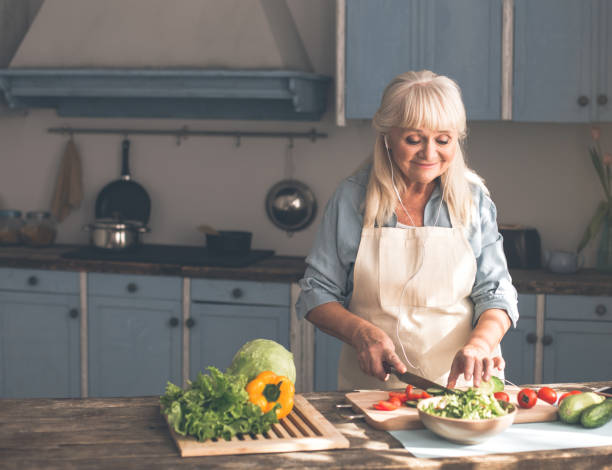 istock Happy senior lady preparing healthy food in kitchen 962066724