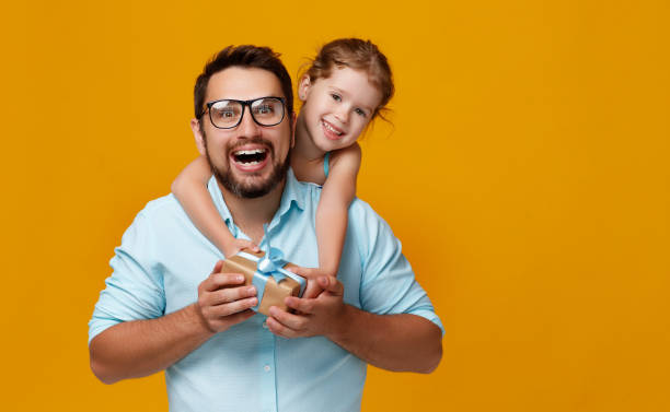 happy father's day! cute dad and daughter hugging on yellow background happy father's day! cute dad and daughter hugging on colored yellow background happy fathers day funny stock pictures, royalty-free photos & images