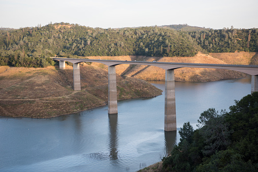 Highway 49 bridge crosses the drought-stricken New Melons Lake in the Sierra Foothills of California, USA.