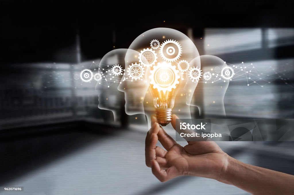 Hand holding light bulb and cog inside. Idea and imagination. Creative and inspiration. Innovation gears icon with network connection on human heads on metal texture background. Innovative technology in science and industrial concept Contemplation Stock Photo