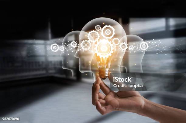 Hand Holding Light Bulb And Cog Inside Idea And Imagination Creative And Inspiration Innovation Gears Icon With Network Connection On Human Heads On Metal Texture Background Innovative Technology In Science And Industrial Concept Stock Photo - Download Image Now