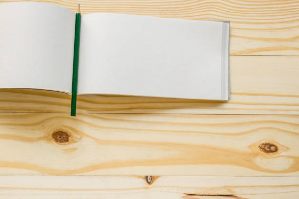 istock Open book with pencil on wood background 962071988