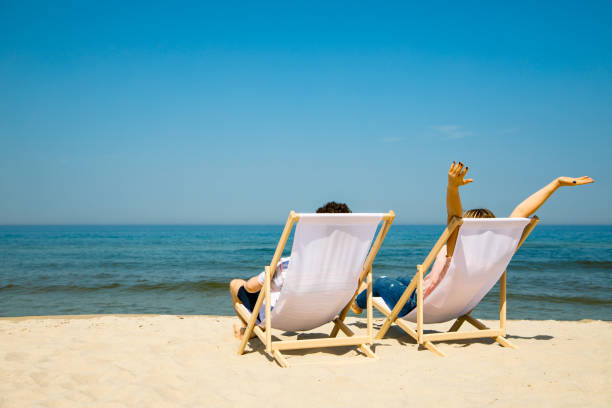 istock Woman and man relaxing on beach 962074812