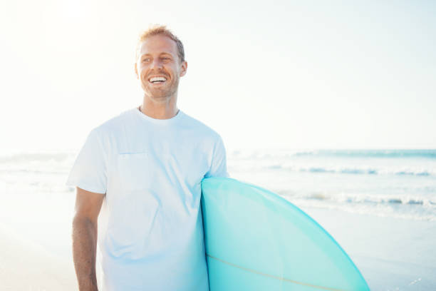 istock Portrait of surfer with a surfboard on the beach 962076334