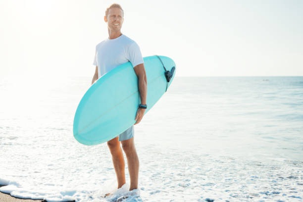 Portrait of surfer with a surfboard on the beach stock photo