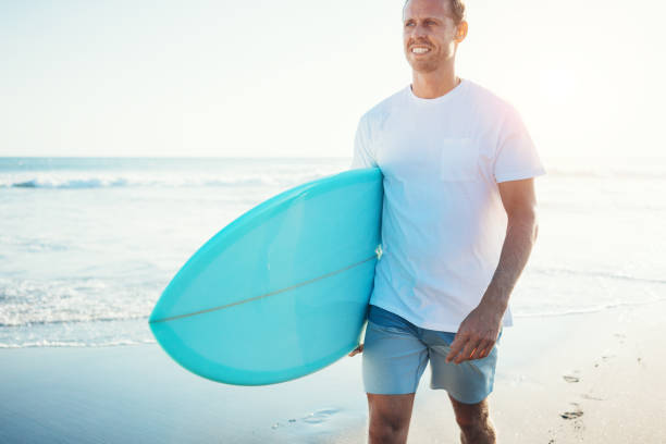 istock Surfer walking with a surfboard on the beach 962076358