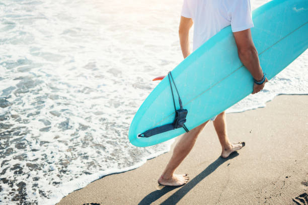 istock Surfer walking with a surfboard on the beach 962076440