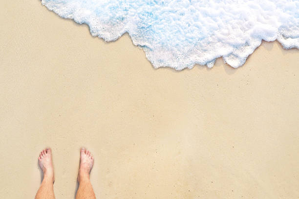 istock standing on the beach with wave motion coming to the foot 962076558