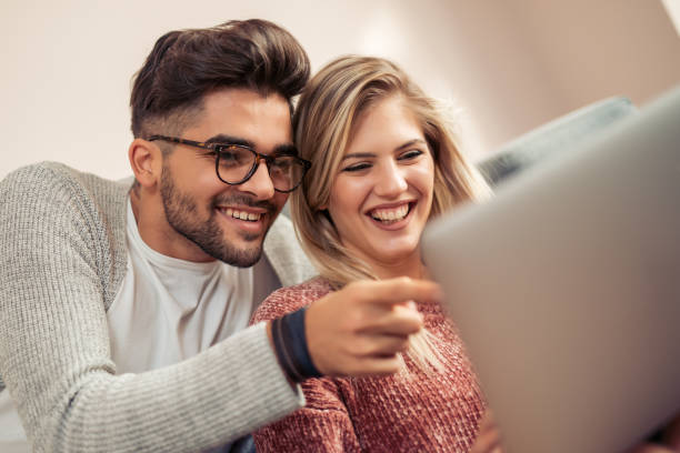 istock Happy couple relaxing on their couch and using laptop 962076776