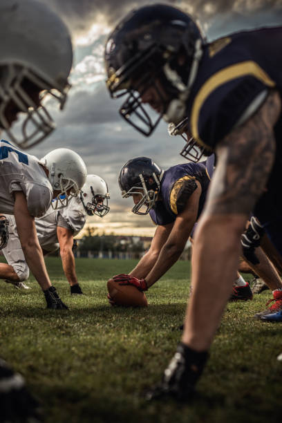 American football players on a beginning of the match. American football players confronting before the beginning of a match. offensive line stock pictures, royalty-free photos & images