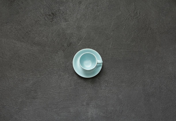 istock Blue porcelain empty coffee cup on a black stone background. Empty cup top view. 962077994