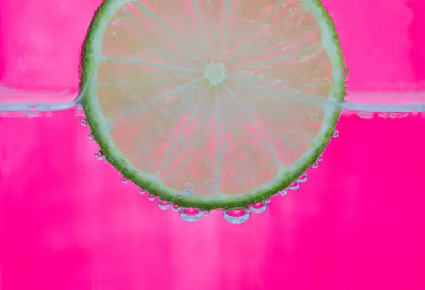 a slice of lime in a glass with sparkling water