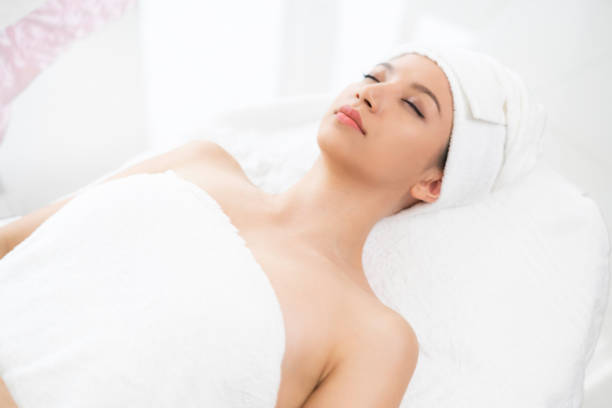 istock Relaxed young woman lying on spa bed for massage. 962081060