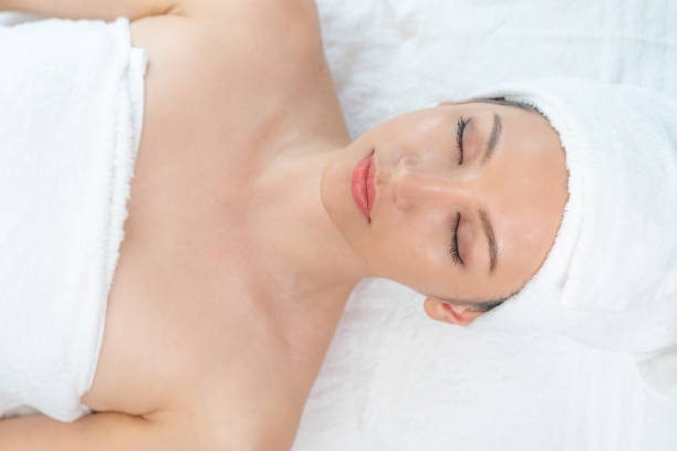 istock Relaxed young woman lying on spa bed for massage. 962081094