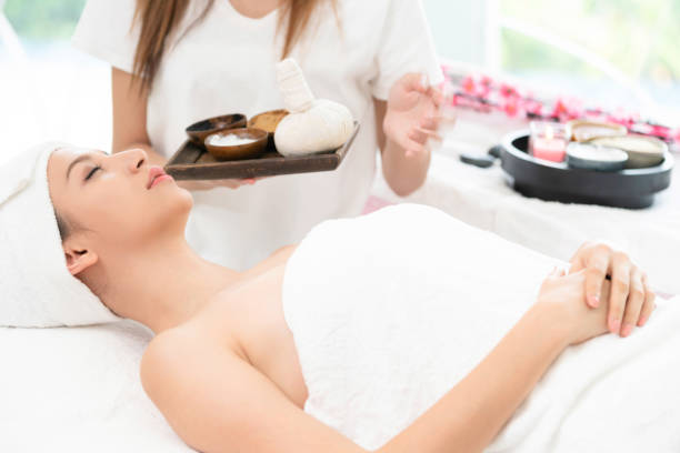 istock Relaxed woman on spa bed. Therapist in background. 962081098