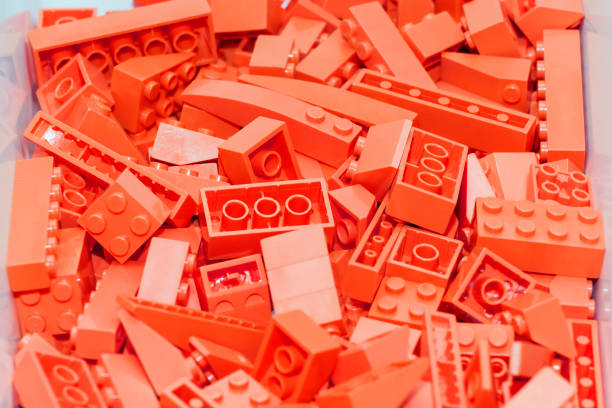 istock Red plastic construction block designer. Background of bright plastic building blocks. 962088068