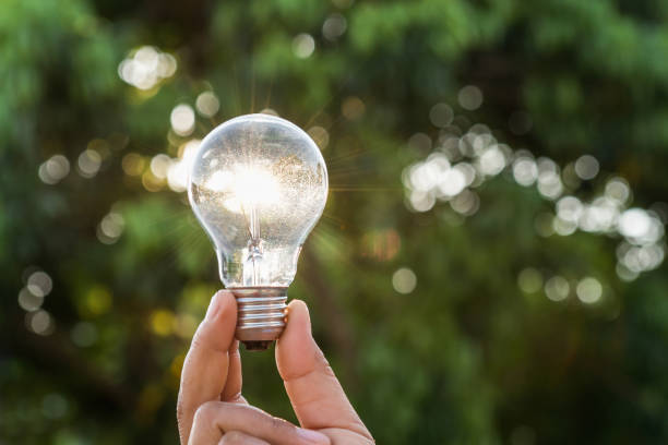 istock hand holdging light bulb with solar energy. power eco concept 962088648