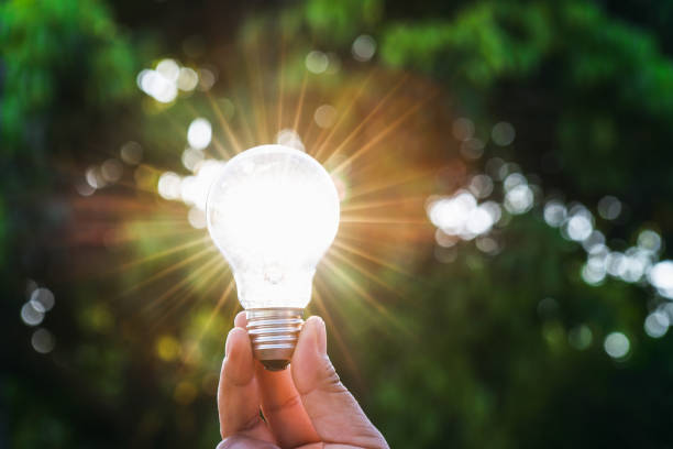 istock hand holdging light bulb with solar energy. power eco concept 962088658