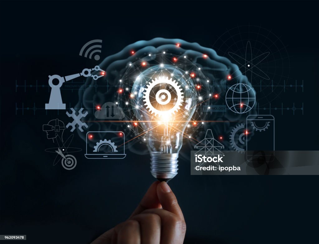 Hand holding light bulb and cog inside and innovation icon network connection on brain background, innovative technology in science and industrial concept Innovation Stock Photo