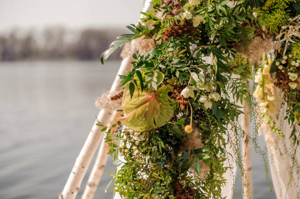 istock Wedding arch decorated with tropical flowers and white fabric 962094002