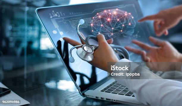 Medicine Doctor Team Meeting And Analysis Diagnose Checking Brain Testing Result With Modern Virtual Screen Interface On Laptop With Stethoscope In Hand Medical Technology Network Connection Concept Stock Photo - Download Image Now