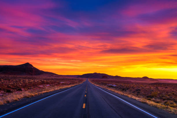 dramatischen sonnenuntergang über eine leere straße in utah - sonnenuntergang stock-fotos und bilder