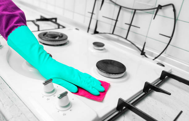 istock Hand in rubber gloves cleans a kitchen gas stove. 962101406