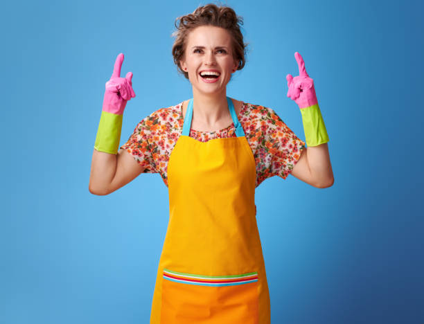 istock smiling young woman pointing up at something on blue 962102492
