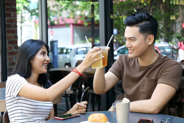 istock Young Asian man woman cheers drinks glasses 962103142