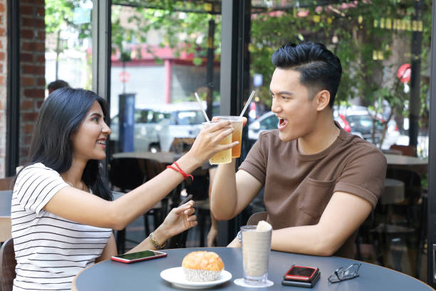 istock Young Asian man woman cheers drinks glasses 962103216