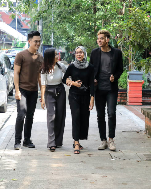 Young Asian man woman walk talk fun colleague student  outdoor roadside