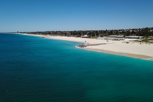 Aerial shot of a Blue Baywatch House on a pier surrounded by a turquoise waters of Indian Ocean- South City Beach, Western Australia.