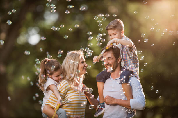 istock Young happy family among bubbles during spring day in nature. 962107176