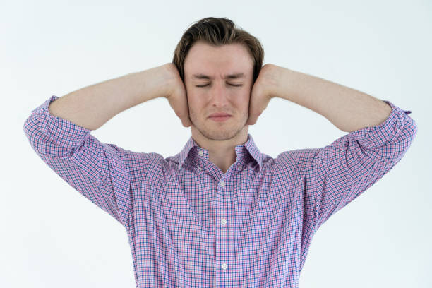 istock Tensed man covering ears with hands with his eyes closed 962107434