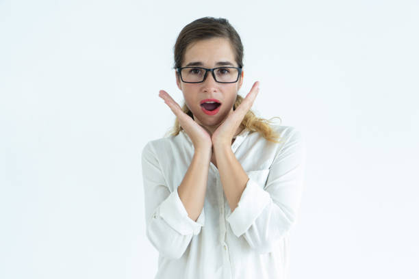 istock Surprised pretty young woman raising hands and looking at camera 962107450
