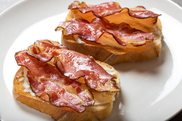 istock Two slices of fried bread with butter and fried bacon 962111524
