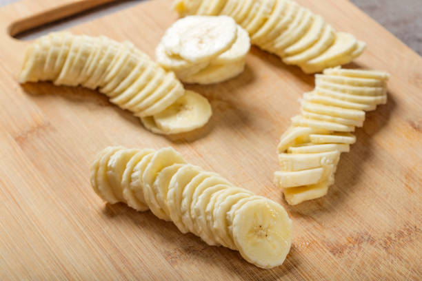 istock Fresh raw banana slices on wood cutting board 962111572