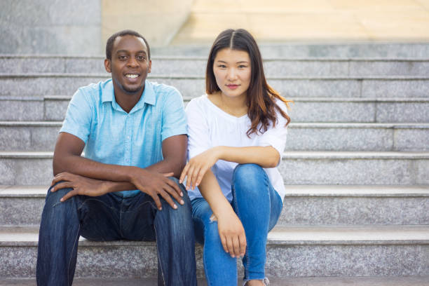 istock Portrait of smiling multiethnic students sitting on staircase 962113166