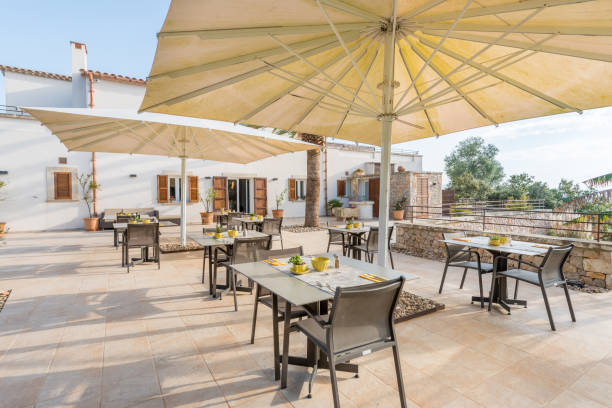 Cafe tables from hotel under white umbrellas Tables in outdoor terrace from a hotel restaurant in Majorca, Balearic Islands, Spain building terrace stock pictures, royalty-free photos & images