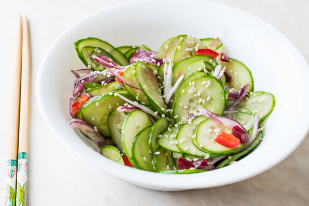 istock Asian Cucumber Salad with Sesame and served with Chopsticks. 962117556