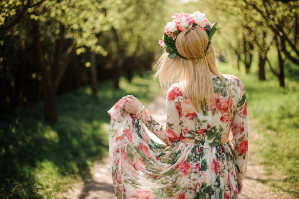 vista traseira da mulher loira vestida de flor vestido e grinalda na cabeça dela - floral dress - fotografias e filmes do acervo