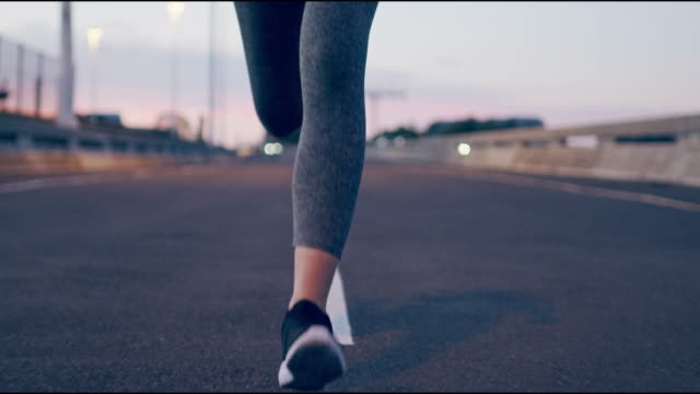 Rekaman video 4k dari seorang wanita yang tidak dapat dikenali keluar untuk berlari di kota