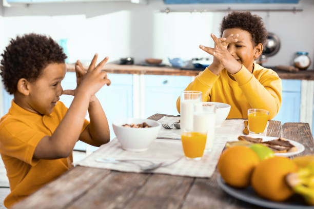 istock Cheerful boys thumbing their noses at each other during breakfast 962123270