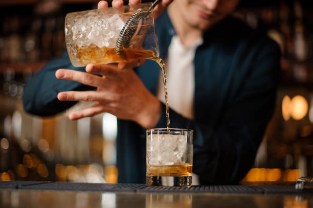 istock Barman pouring fresh and cold alcoholic drink into a glass 962123334