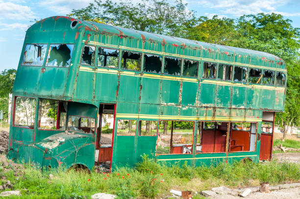 istock Old abandoned green double decker bus with broken and shattered window glass, damaged and left to rust 962131910