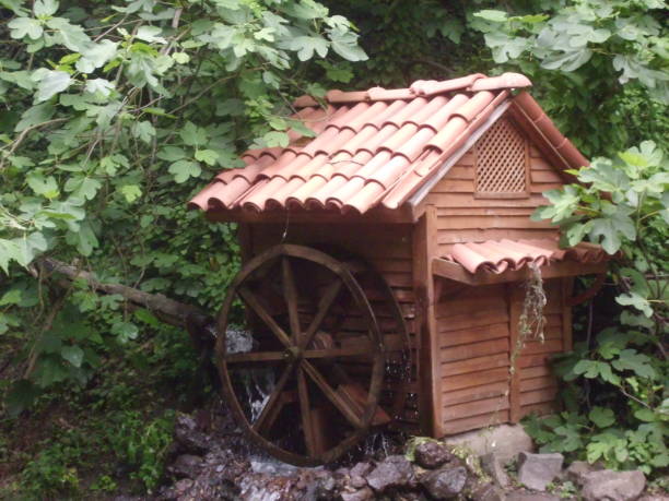 Old wooden water wheel next to a mill