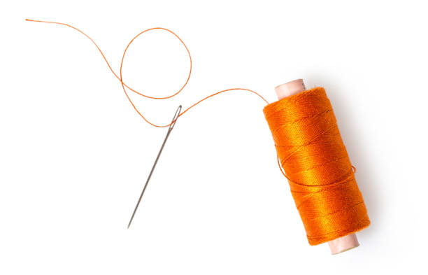 bobine de fil avec une aiguille - thread sewing item photos et images de collection