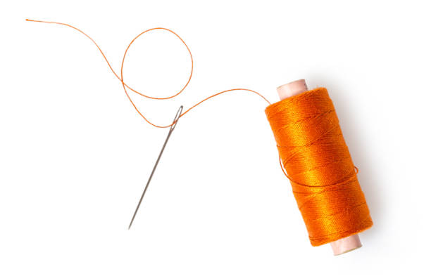 spool of thread with a needle - sewn imagens e fotografias de stock